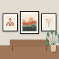 Three framed boho prints hanging above a wooden sideboard